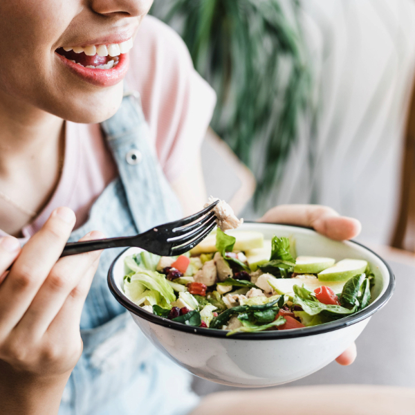 mujer comiendo una ensalada como parte de un menú saludable para la semana