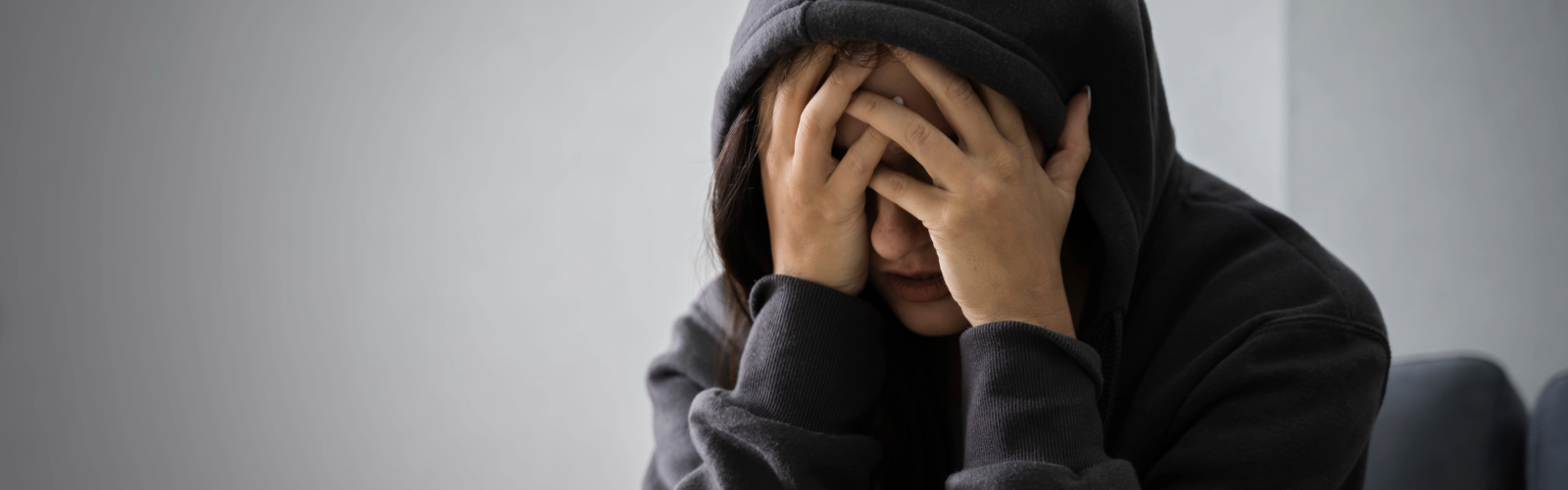 mujer joven deprimida en casa, asociada a síntomas de depresión y bienestar emocional