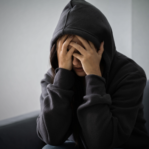 mujer joven deprimida en casa, asociada a síntomas de depresión y bienestar emocional
