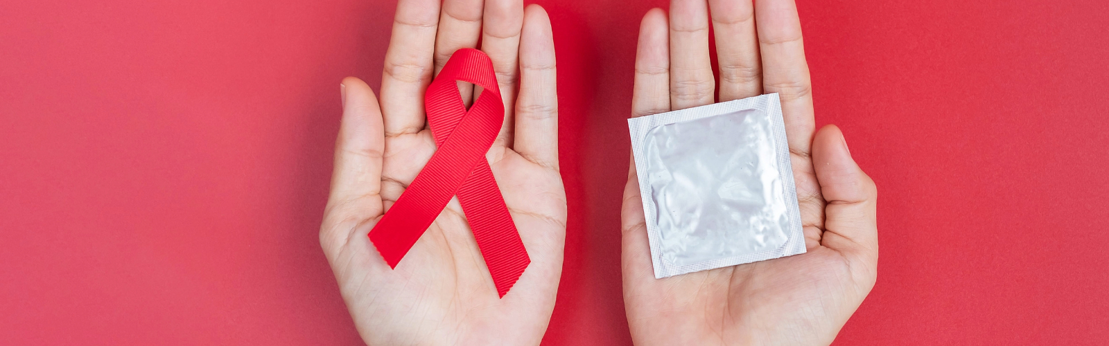 manos sosteniendo una cinta roja como símbolo de la prevención de las its