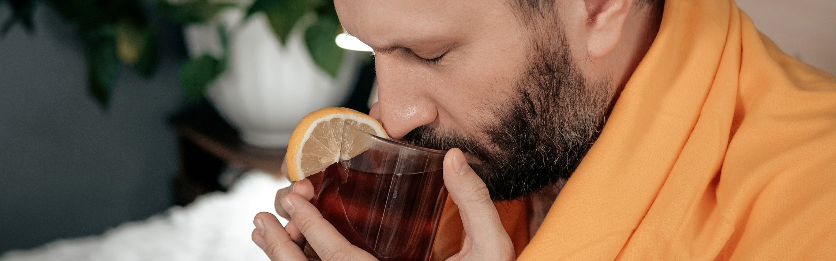 hombre tomando té con limón como uno de los remedios caseros para la tos con flema y el alivio de la congestión