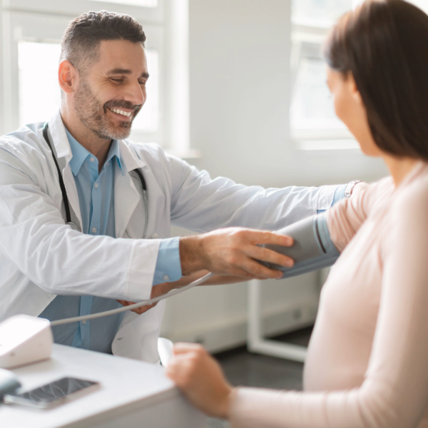 Doctor en chequeo médico midiendo la presión arterial a una paciente 