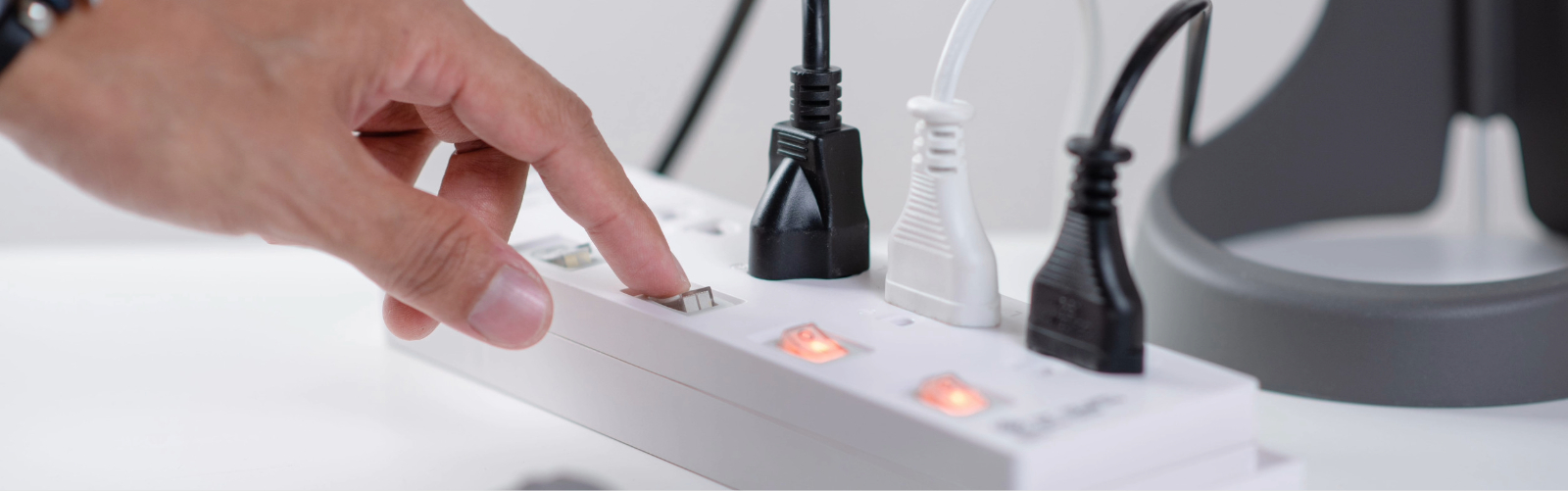 mano apagando una multitoma eléctrica para mejorar la seguridad eléctrica en el hogar