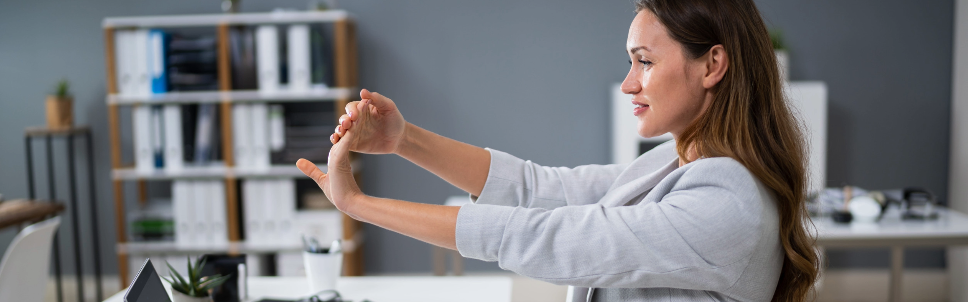 Mujer estirando su brazo y haciendo una pausa en su trabajo