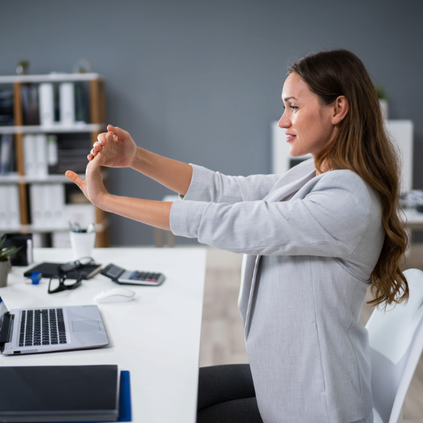 Mujer estirando su brazo y haciendo una pausa en su trabajo