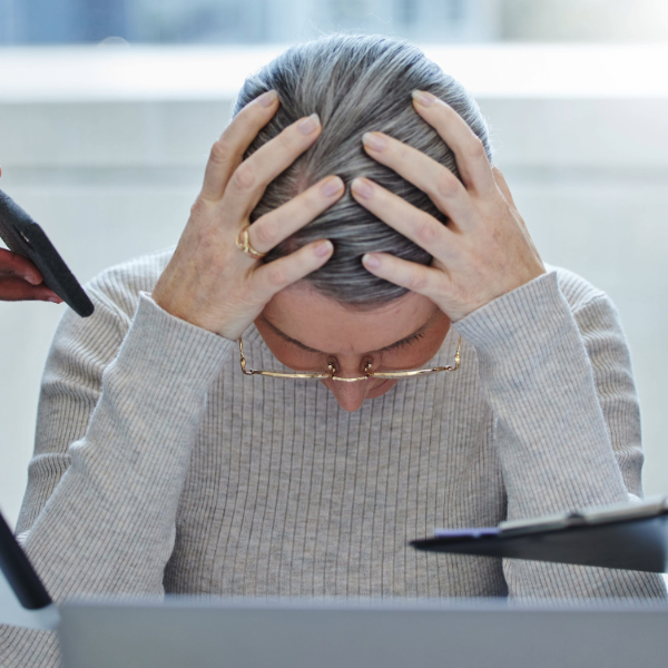 mujer en oficina mostrando signos de estrés laboral, reflejando la importancia de la salud mental en el trabajo