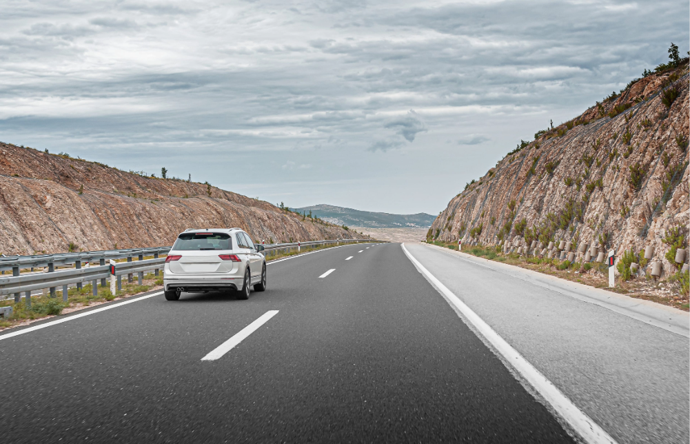 Automóvil circulando por carretera representando la seguridad vial y el movimiento en la vía