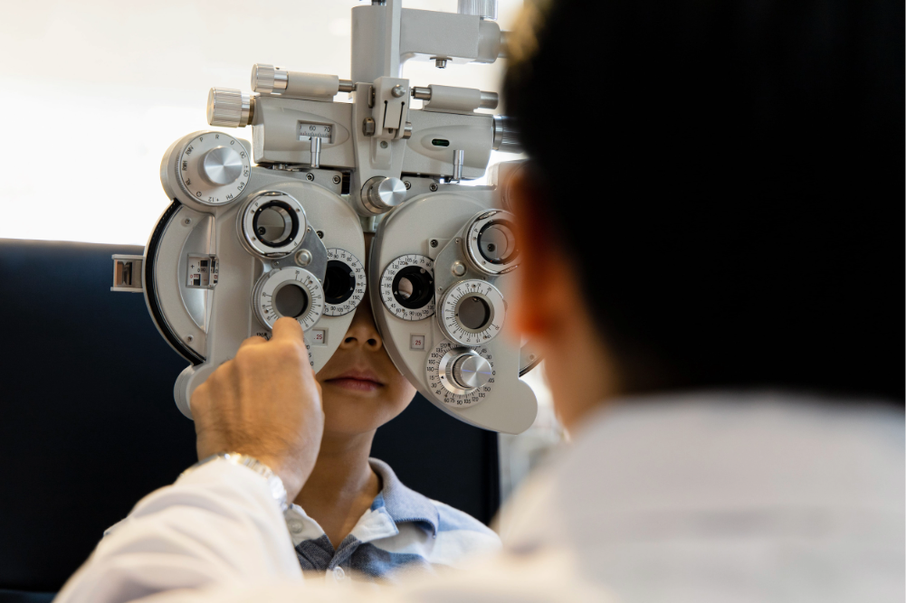 optometrista examinando la visión de un niño con un autorrefractor durante un control oftalmológico
