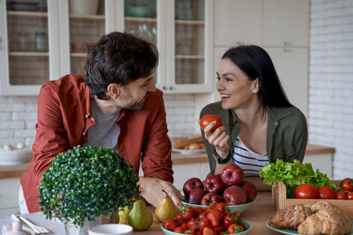 mujer joven sosteniendo un tomate fresco como parte de una alimentación saludable