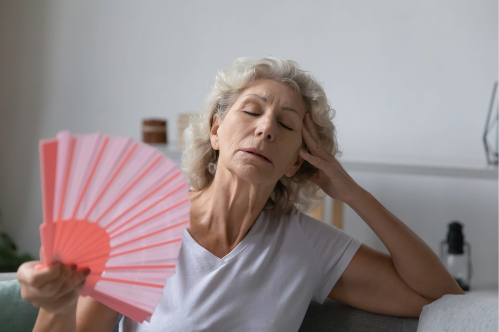 mujer con abanico debido a los sofocos asociados con la menopausia